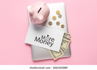 Paper Sheet With Text MORE MONEY, Laptop And Piggy Bank On Color Background. New Year Goals