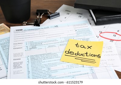 Paper sheet with text TAX DEDUCTIONS and individual tax return form on table - Shutterstock ID 611523179