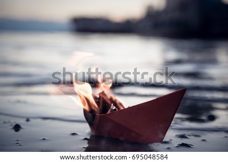 A paper ship burns on fire