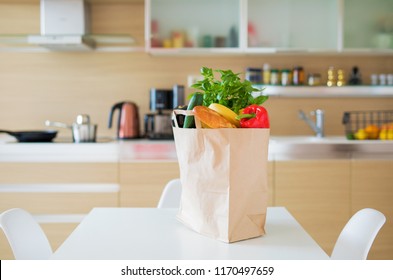 Paper Shopping Bag Full With Groceries Products On Kitchen Table