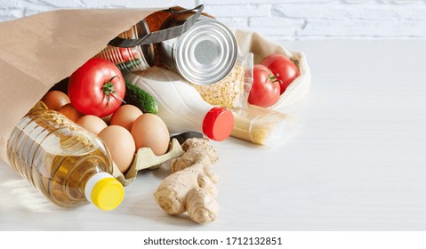 Paper Shopping Bag With Various Food. Food Donation, Safe Delivery Service Concept. Pasta, Eggs, Canned Food, Bottle Of Oil And Milk In A Grocery Shopping Bag.