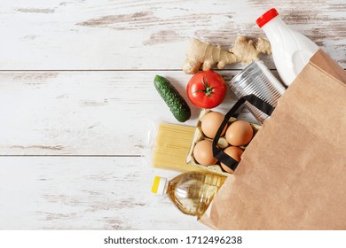 Paper Shopping Bag With Various Food. Food Donation, Safe Delivery Service Concept. Pasta, Eggs, Canned Food, Bottle Of Oil And Milk In A Grocery Shopping Bag.