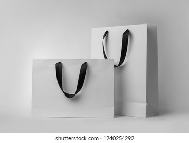 Paper Shopping Bags With Ribbon Handles On White Background. Mockup For Design