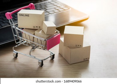 Paper shopping small box express in a shopping cart and laptop notebook on wood table background. Online shopping concept. - Shutterstock ID 1689409066
