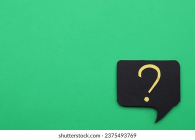Paper speech bubble with question mark on green background, top view. Space for text