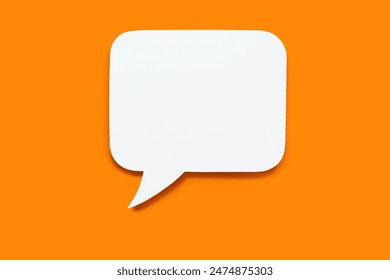 Paper speech bubble in the shape of a rectangle on a orange background. Flat white chat icon in the form of an empty speech bubble. Free space for text or image. Internet communication concept