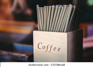 Paper straws in coffee word on wooden box, paper cocktail tubes, eco environmentally friendly straws