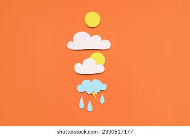 Paper sun with clouds and rain drops on red background. Weather forecast concept - Powered by Shutterstock
