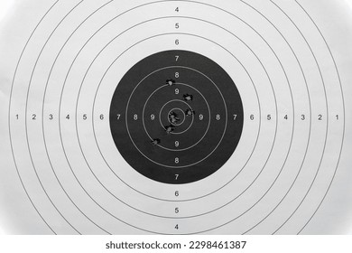A paper target for shooting at a shooting range with bullet holes in the center.