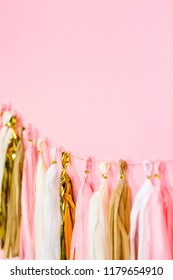 Paper Tassel Garland On A Pink Wall At The Kids Birthday Party.