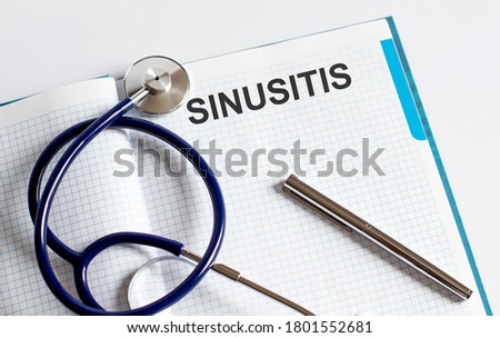 Paper with text SINUSITIS on a table with stethoscope