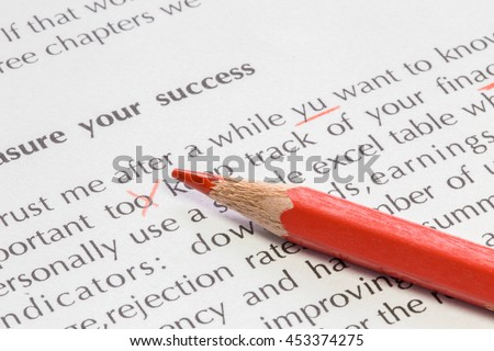Paper with text and some wrong spelling corrected and a red pencil proofreading concept