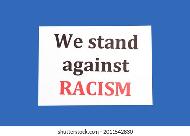 Paper With Text WE STAND AGAINST RACISM On Color Background