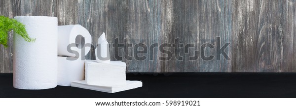 Paper tissue, paper towel\
and napkins on wooden background. Wide panoramic image. Copy\
space.