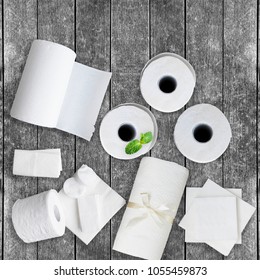 Paper Tissue, White Toilet  Paper Rolls, Towels, Napkins, Cotton Pads Stacked On Rustic Wooden Table. Top View. Copy Space.