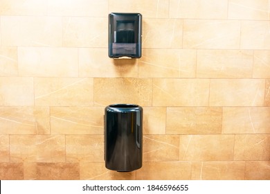 Paper Towel Black Dispenser And A Trash Can At The Bottom For Used Paper Towels On The Wall In A Public Toilet