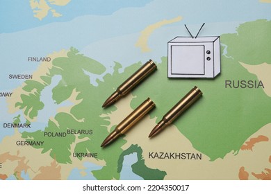 Paper TV And Bullets On World Map, Flat Lay. Hybrid Warfare Concept