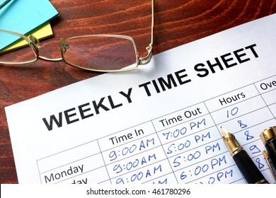 Paper With Weekly Time Sheet On A Table.