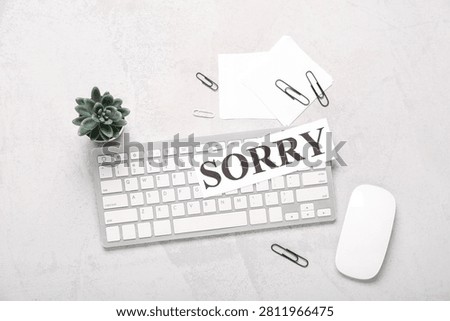 Paper with word SORRY, notes and computer keyboard on white grunge background