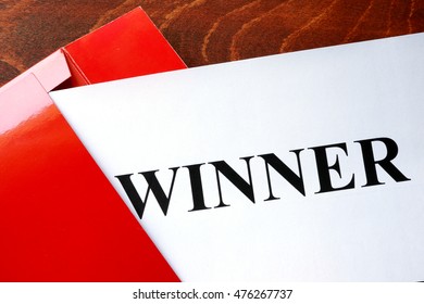 Paper With Word Winner And Red Envelope.