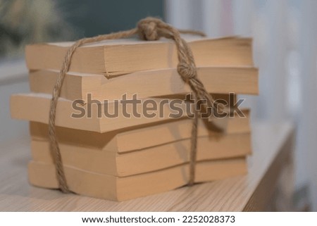 Paperbacks with thick thread tied together in a pile