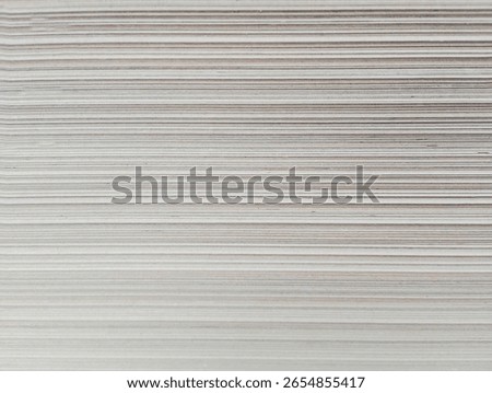 Paperboard Sheet Stack,Neatly aligned stack of flat paperboard sheets, highlighting the uniform thickness and smooth edges for packaging or printing use.