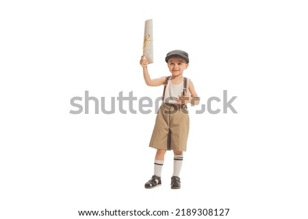 Paperboy, newsboy. Cute happy kid in retro style shorts holding newspaper isolated on white studio background. Vintage style concept. Friendship, hobbies, art, eras comparison and children emotions