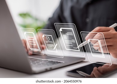 Paperless workplace idea, e-signing, electronic signature, document management. A businessman signs an electronic document on a digital document on a virtual notebook screen using a stylus pen.  - Shutterstock ID 2064550976