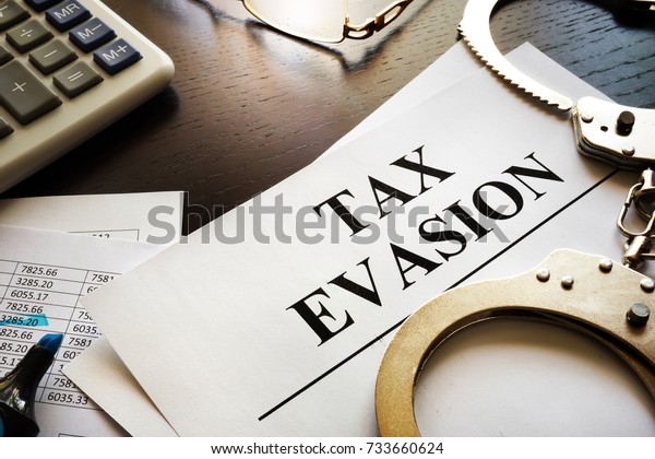 Papers about tax evasion on a desk. Tax
avoidance concept.