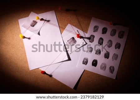 The papers are connected with threads on the board