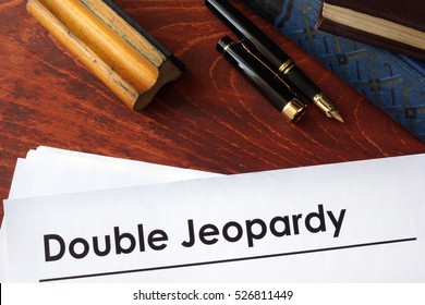 Papers With Title Double Jeopardy On A Table.