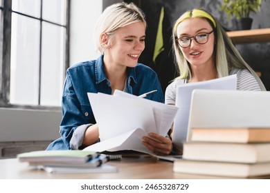 Paperwork, documents, bills and payments. Caucasian young coworkers female lesbian couple working together, dealing with financial papers cheques at home office - Powered by Shutterstock