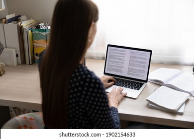 Paperwork On Computer. Back View Of Young Lady Working From Home Focused On Pc Screen Read Electronic Book. Millennial Woman Study Digital Document At Online Database Apply Corrections To Draft Report