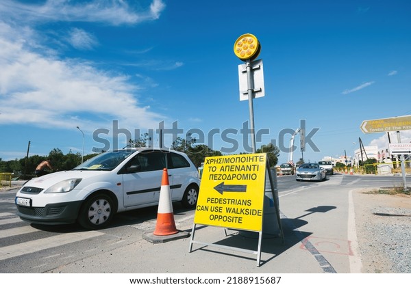 Paphos,\
Cyprus - Oct 29, 2014: Pedestrians can use walk side opposite sign\
in city of Paphos with cars driving on the\
street