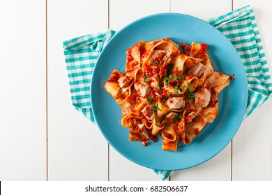 Pappardelle Pasta With Tuna, In Tomato Sauce. Served On A Blue Plate, White Boards In The Background. Top View. 