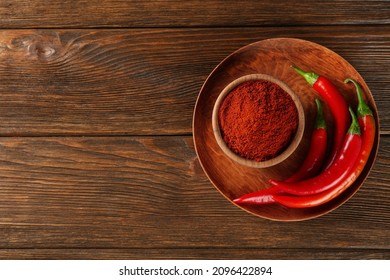 Paprika powder and fresh chili peppers on wooden table, top view. Space for text - Powered by Shutterstock