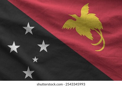 Papua New Guinea flag depicted on folded wavy fabric of old cloth close up - Powered by Shutterstock