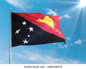 Papua New Guinea national flag waving in the wind against deep blue sky. High quality fabric. International relations concept.