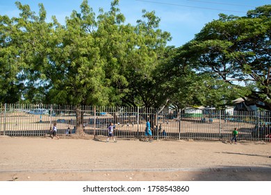 Papua New Guinea, Port Moresby, 13 Of November. Fenced School Area At 9 Mile Roundabout. Children Are Going To School. 