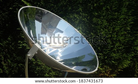 parabolic solar oven in the middle of cooking a dish thanks to solar energy