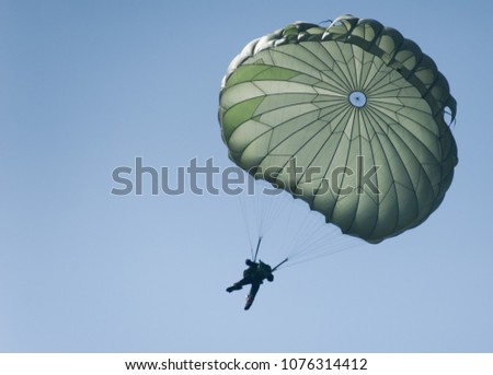 A parachute during a risky operation at sea. A special forces paratrooper jumping from a plane. 