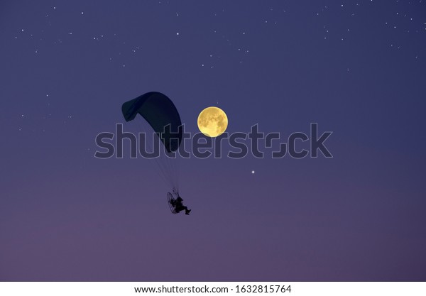 Parachute and
full moon in starry sky in the
evening