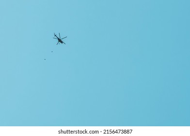 Parachutists Jump From A Helicopter At High Altitude. Parade On Victory Day May 9. The Parachutes Have Not Been Deployed Yet.