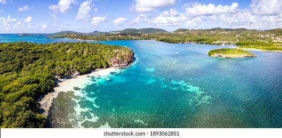 Paradise beach and bay in Carribean archipelago in Antilles with transparent turquoise sea water and coral reefs. Aerial drone panorama of coast white sand and green forest, summer holidays vacation
