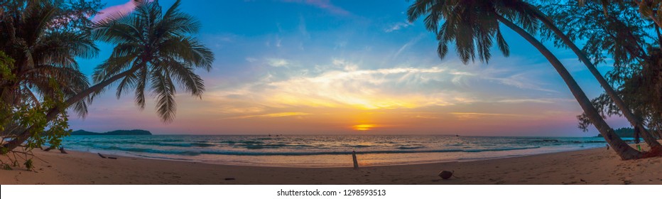 Paradise beach sunset landscape with tropical palm trees silhouettes. Summer travel vacation getaway colorful concept photo from sea ocean water