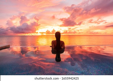 Paradise luxury resort honeymoon getaway destination at idyllic Caribbean tropical landscape hotel, woman silhouette swimming in infinity pool watching sunset serene. Winter getaway at dusk. - Shutterstock ID 1655942425