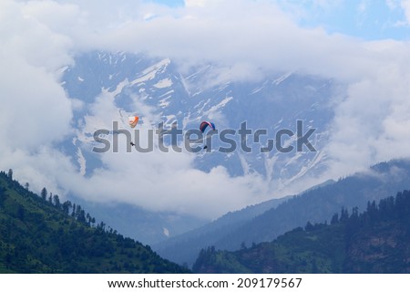 Paraglider flying in the Kullu valley in the village . District Manali, Himachal Pradesh, India.