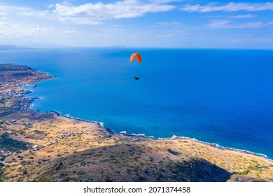 Paraglider flying over Milatos village, Crete, Greece. 