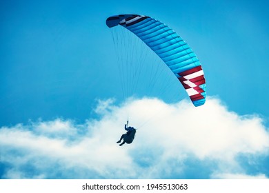 Paraglider Flying Over The Mountains. Active People Enjoying In Extreme And Adrenalin Sports. Paragliding On A Sunny Afternoon.