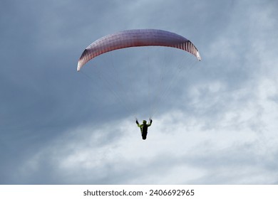 Paraglider silhouette close up against clouds. Paragliding on Pálava hill in Czech Republic.